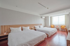 A hotel room with two beds, wooden headboards, a small table, two chairs, and a large window with curtains. - Timeless Recreation Hotel (Huanggang)