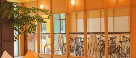 Una habitación con un sofá, una mesita y una pared decorada con bicicletas.