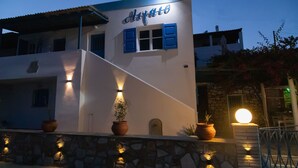 A building with a sign reading "Alarco" and a stone wall with potted plants. - Aigaio View Studios & Rooms (Syros)