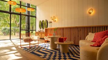Un moderno salón con un ventanal grande, un muro de listones de madera y un tapete de cuadros.