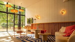 Un salon moderne doté d  ’une grande fenêtre, d’un mur avec des lambris en bois et d’un tapis à carreaux.