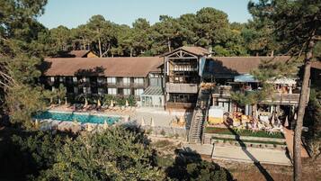 A resort with a swimming pool, outdoor seating, and a building with multiple balconies.