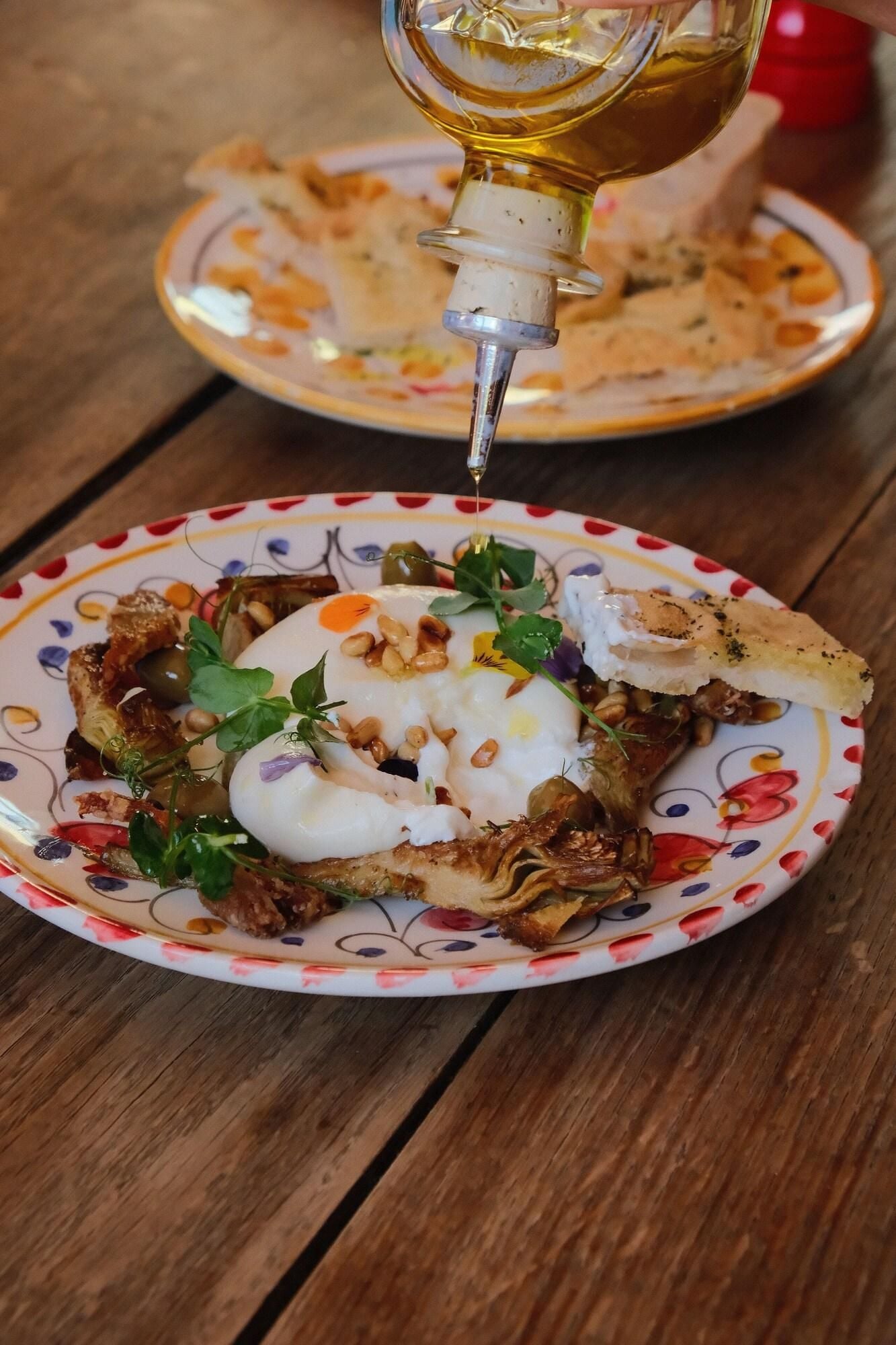 Une assiette de nourriture sur laquelle on verse une sauce.