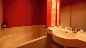 A bathroom with a bathtub, a sink, and a mirror. - La Baignoire Hotel du Golf Lacanau (Lacanau)