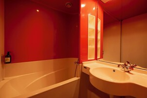 Un baño con bañera, lavamanos y espejo.
