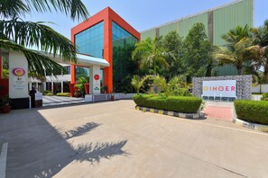 A modern building with a glass facade, a red and white entrance, and a sign reading 'GINGER'. - Ginger Kheda (Kheda)