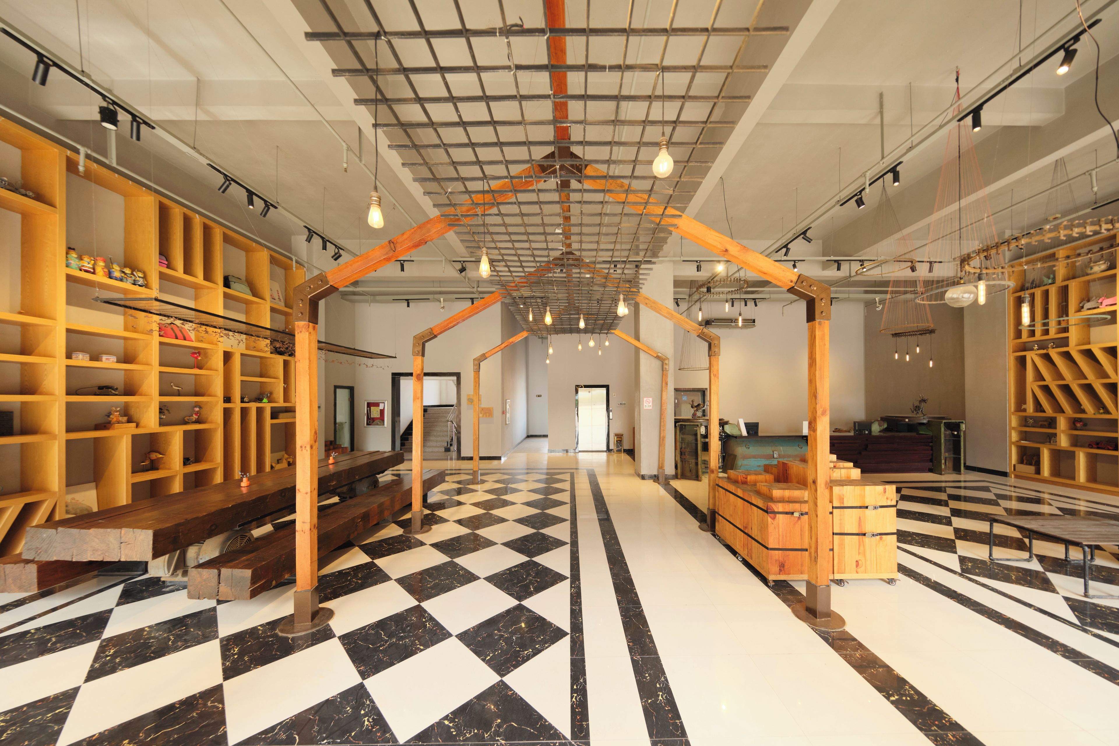 A spacious interior with a checkered floor, wooden shelving units, and a central wooden structure.