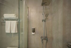 Una ducha moderna con cabezal de ducha de mano y llave de pared.