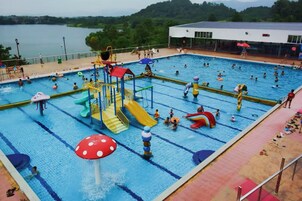 A swimming pool with multiple lanes, water slides, and a lifeguard stand.