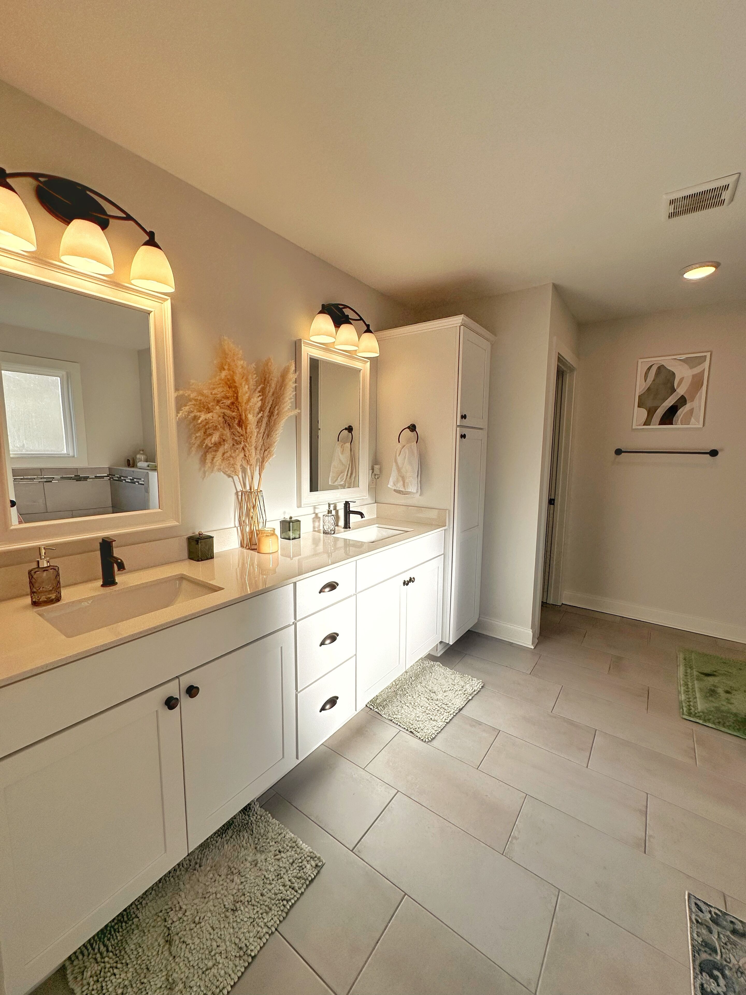 Un baño moderno con un espejo grande, lavamanos dobles y un mueble con cajones.