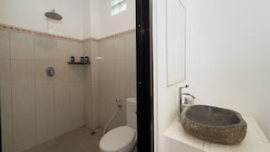 A bathroom with a shower, toilet, and a stone sink. - Canggu Surf Paradise (Canggu)