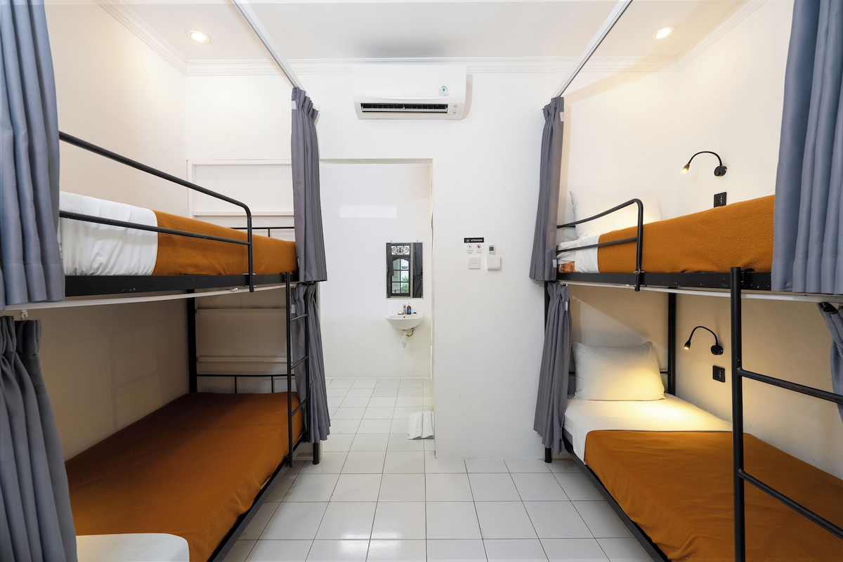 Une chambre de dortoir équipée de lits superposés, d’un lavabo et d’un appareil de climatisation.
