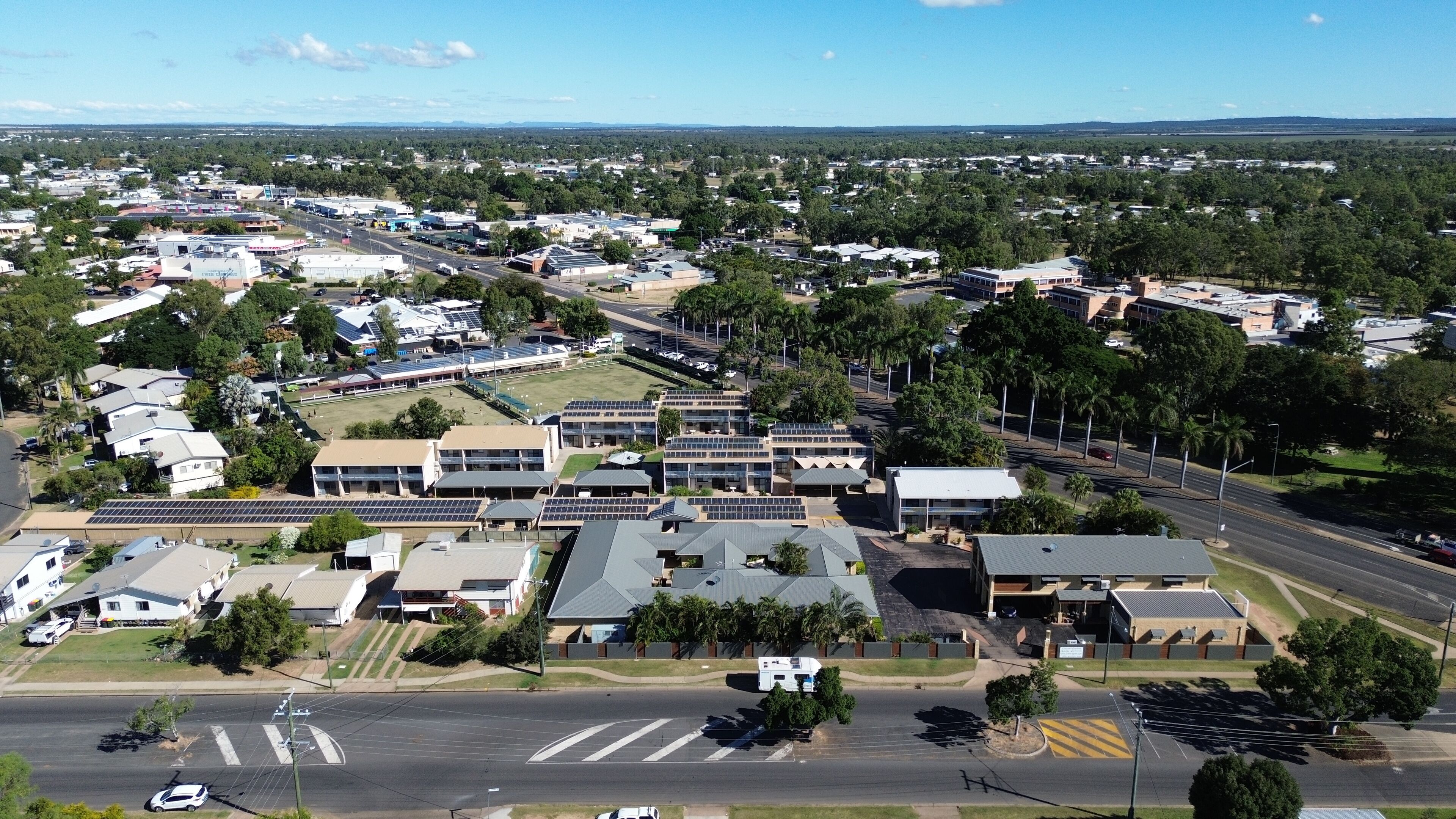 An aerial view of a town with various buildings, roads, and greenery.