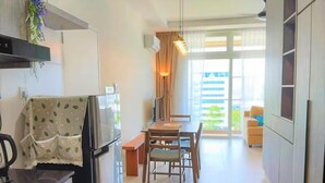Una cocina moderna con refrigerador, estufa y comedor con sillas y mesa.