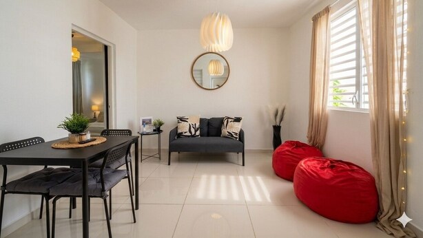 Un salon moderne avec une table à manger, un canapé et des fauteuils en forme de sac de haricots rouges.