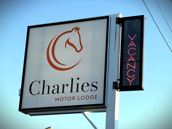 Une enseigne pour le « Charlies Motor Lodge », avec un logo représentant un cheval.