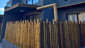 A modern building with large windows and a wooden fence. - MHV Milagres - Guadalupe 08 (Passo de Camaragibe)