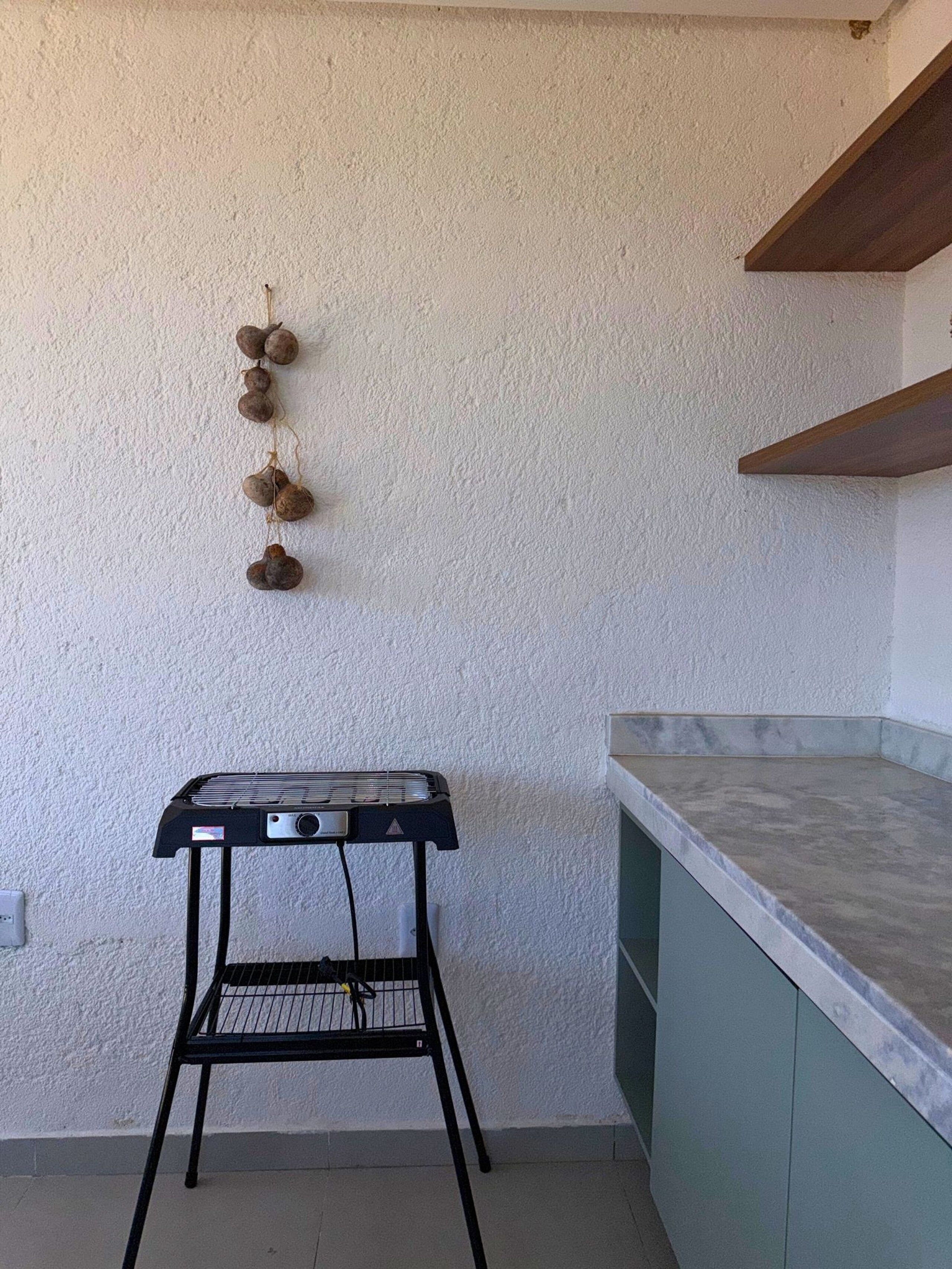A kitchen with a marble countertop, a black metal stand, and a wall-mounted decoration.