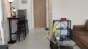 Ein modernes Wohnzimmer mit einer Couch, einem Glastisch und einem Essbereich mit Stühlen und einem Tisch.