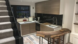 Une cuisine moderne dotée d’une cuisinière intégrée, d’un évier et d’un coin bar.