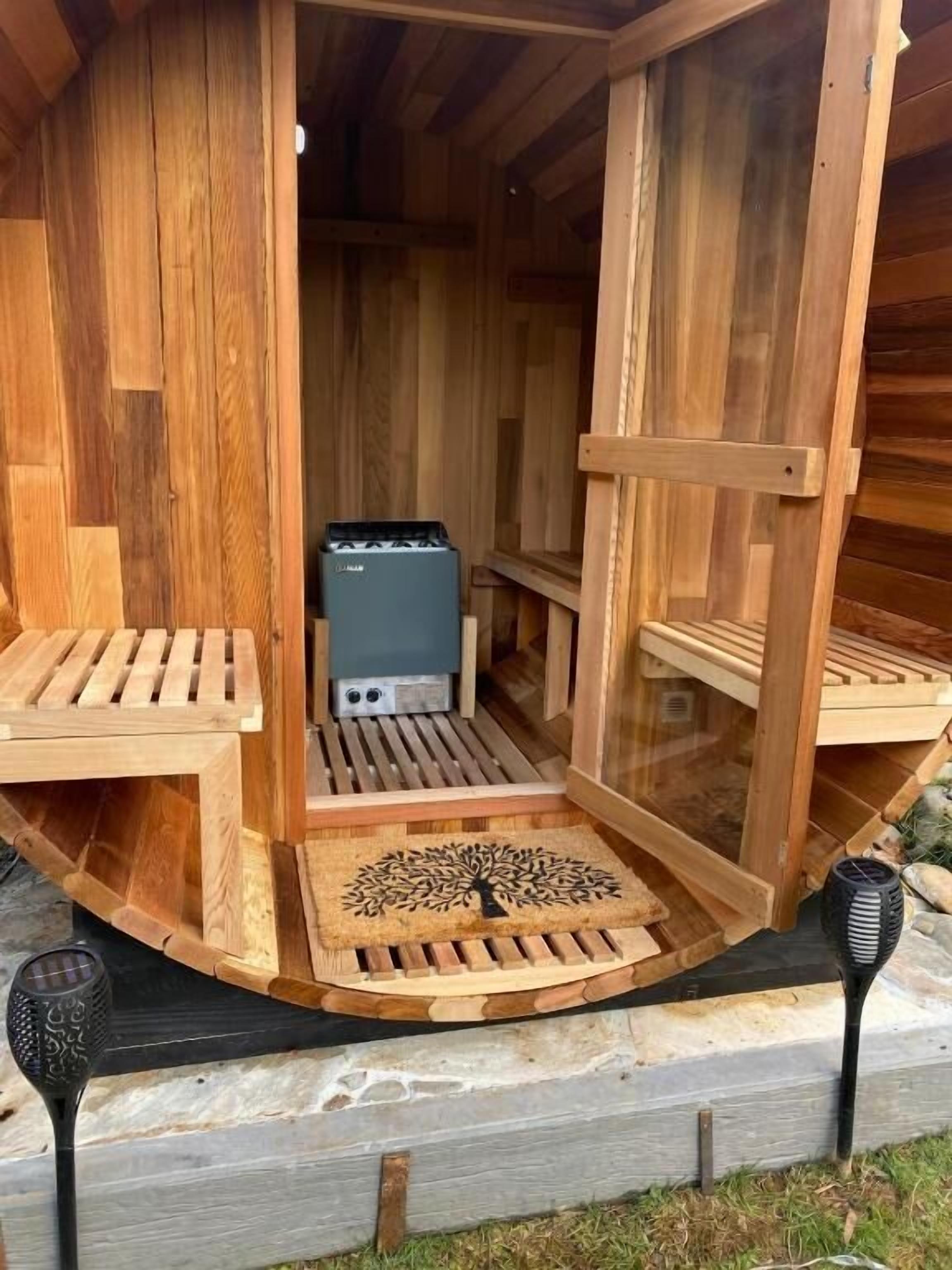 A wooden sauna structure with benches and a central heating unit.
