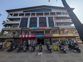 Un hotel llamado "Hotel Padubidri Comforts" con varias tiendas en la planta baja, incluyendo "Bharath Cinemas" y "Shreyas Gold & Diamonds".