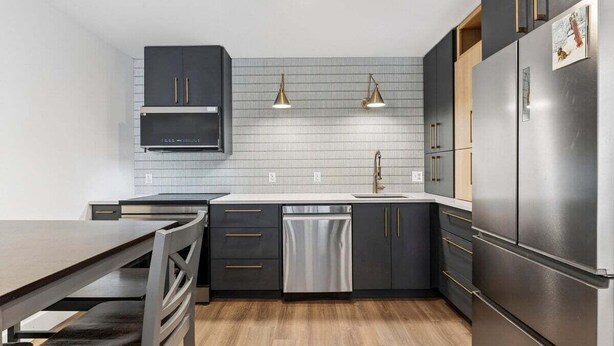 Una cocina moderna con lavavajillas, pileta doble y electrodomésticos de acero inoxidable.
