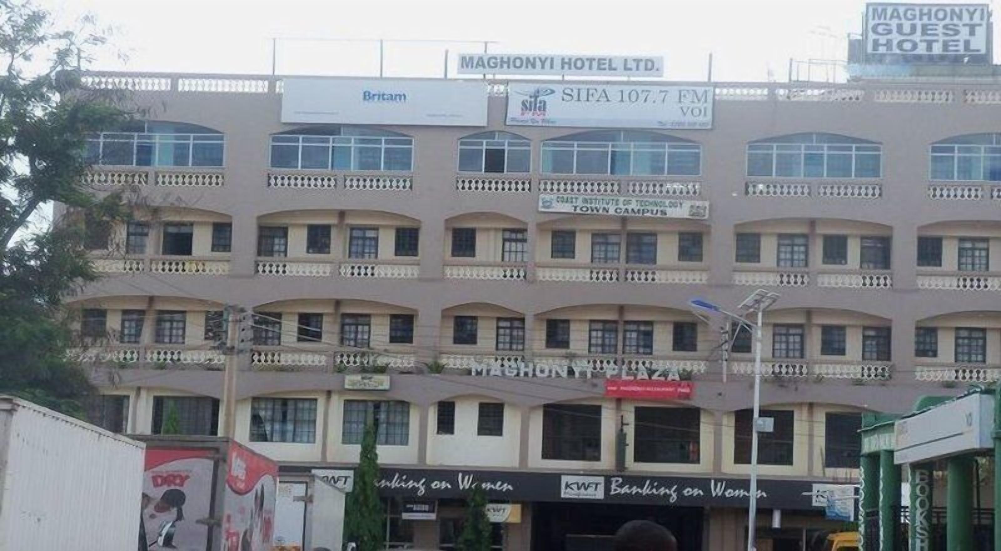 A multi-story building with signs for 'MAGHONYI HOTEL LTD.', 'SIFA 107.7 FM', and 'Westminster University of Technology'.