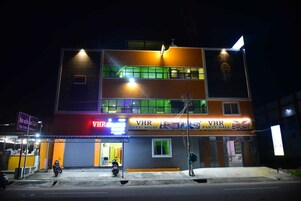 Un edificio de varios pisos con una planta baja que dice "VHR GUEST HOUSE" y un segundo piso que indica "VHR PARTY HALL".