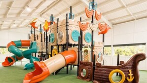 An indoor play area with slides, climbing structures, and a ship-themed playset. - Tahmoor Inn (Tahmoor)