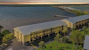 Un hôtel doté d’un grand bâtiment et d’un parking, situé près d’une étendue d’eau.