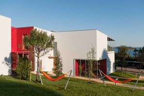 Un edificio moderno con sección de ladrillo rojo y fachada blanca, que ofrece una vista despejada del paisaje circundante.