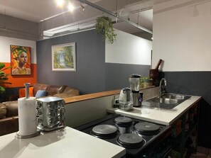 Une cuisine moderne équipée d’une cuisinière à gaz, d’une machine à café et d’un évier.