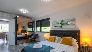 Ett modernt hotellrum med en stor säng, ett skrivbord och en stol.