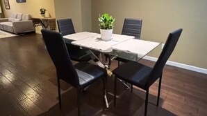 A dining area with a glass table, black chairs, and a potted plant. - 5 Min to Caltrain . Shared Bath with 1 Other Guest . Tech (Sunnyvale)