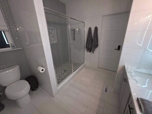 A bathroom with a toilet, a shower with a glass door, and a towel rack. - Lake Anna: Hot Tub, Pool, Beach, Tennis (Mineral)