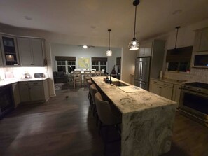A modern kitchen with a marble island, stainless steel appliances, and pendant lighting. - Lake Anna: Hot Tub, Pool, Beach, Tennis (Mineral)