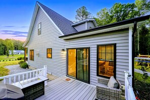 Una casa moderna con terraza, ventanas amplias y un césped cuidado.