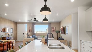 Eine moderne Küche mit einer großen Kochinsel, einer eingebauten Spüle und einem Deckenventilator.