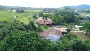 A rural property with two main buildings, surrounded by lush greenery and a small pond. - Muiraquitã Hotel  (Ourilandia Do Norte)