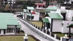 A series of buildings with green roofs and white walls, arranged in a linear fashion along a stone pathway.