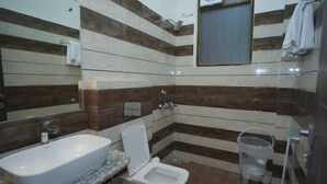 A bathroom with a sink, toilet, and a mirror.