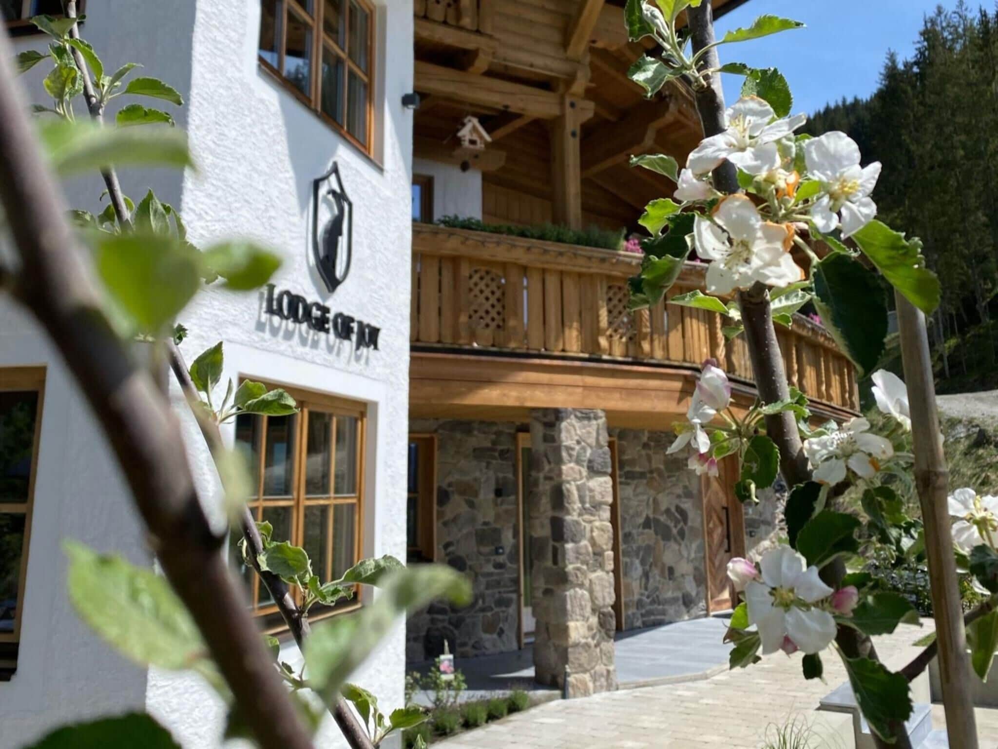 Una cabana amb façana de pedra, balcó de fusta i un rètol que diu "Lodge of Jura".