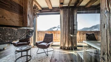 Un intérieur moderne avec des poutres en bois, un mur en pierre et une vue sur les montagnes.
