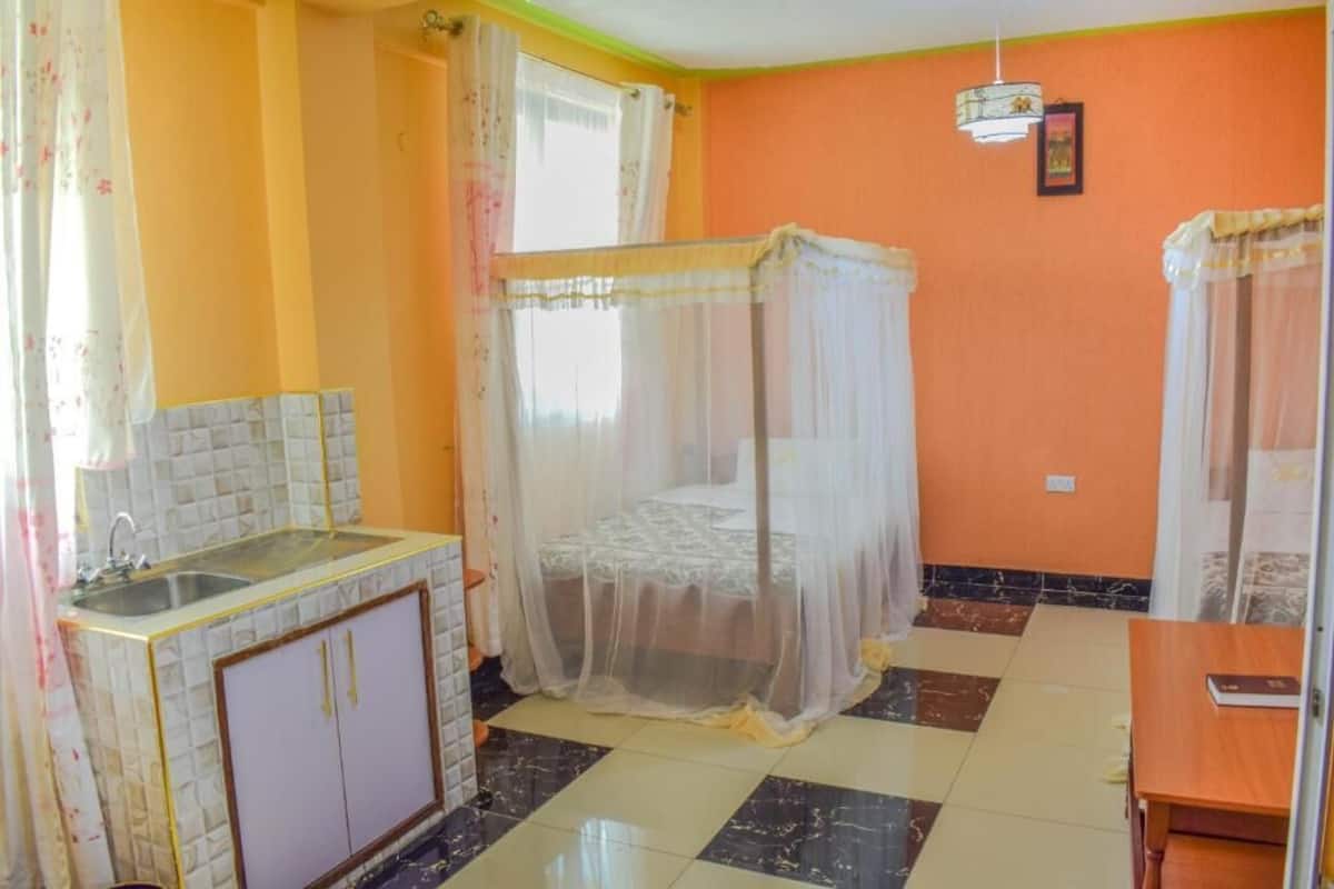 A room with a bed, a sink, and a small table.