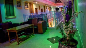 A hotel lobby with a seating area, a staircase, and a decorative plant. - The Joy Hotel Voi (Voi)