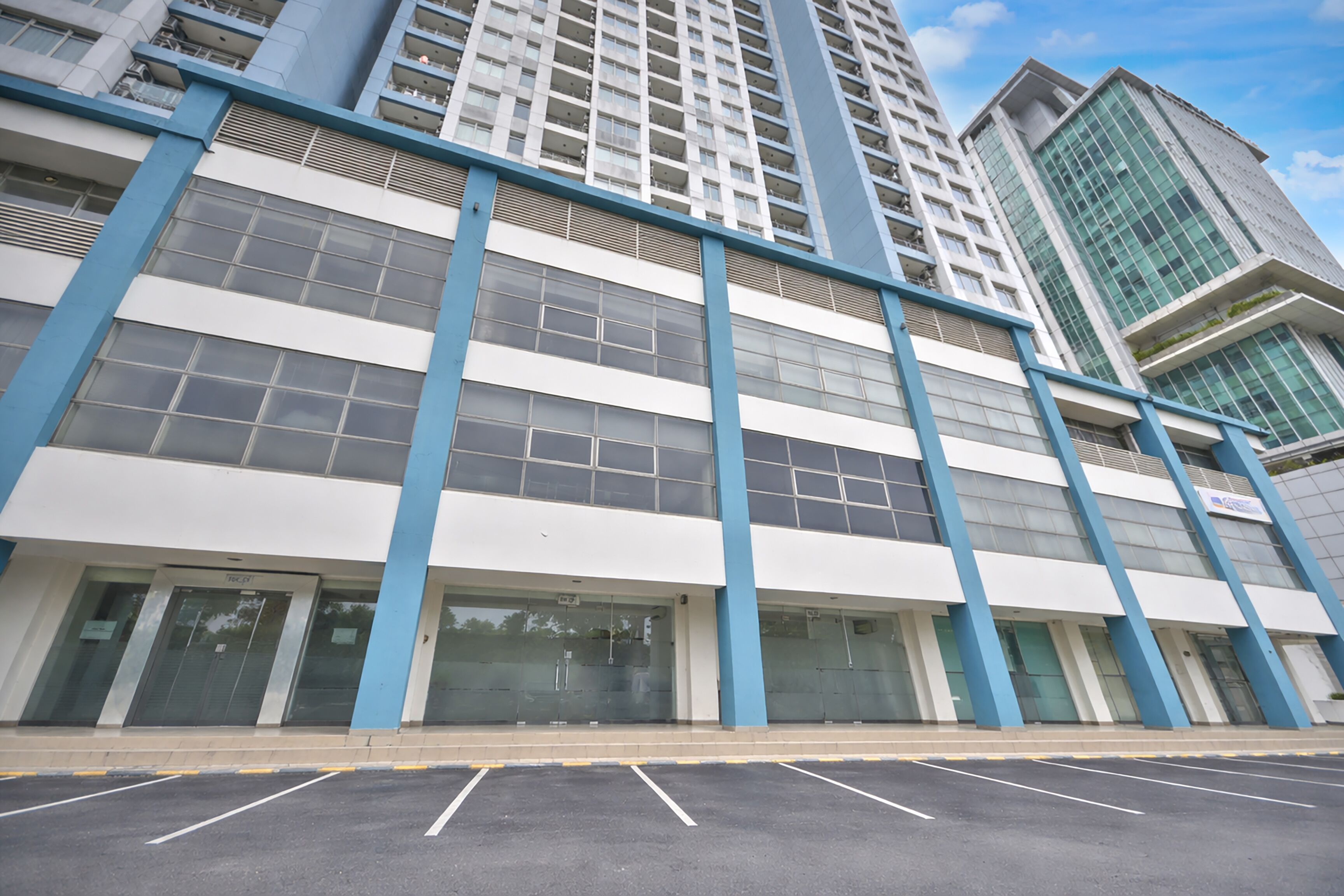 A modern building with large windows and blue accents.