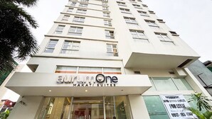 A building with a sign for 'AurumOne Makati Suites' indicating residential and office spaces for lease. - Foura Suites Makati (Makati)