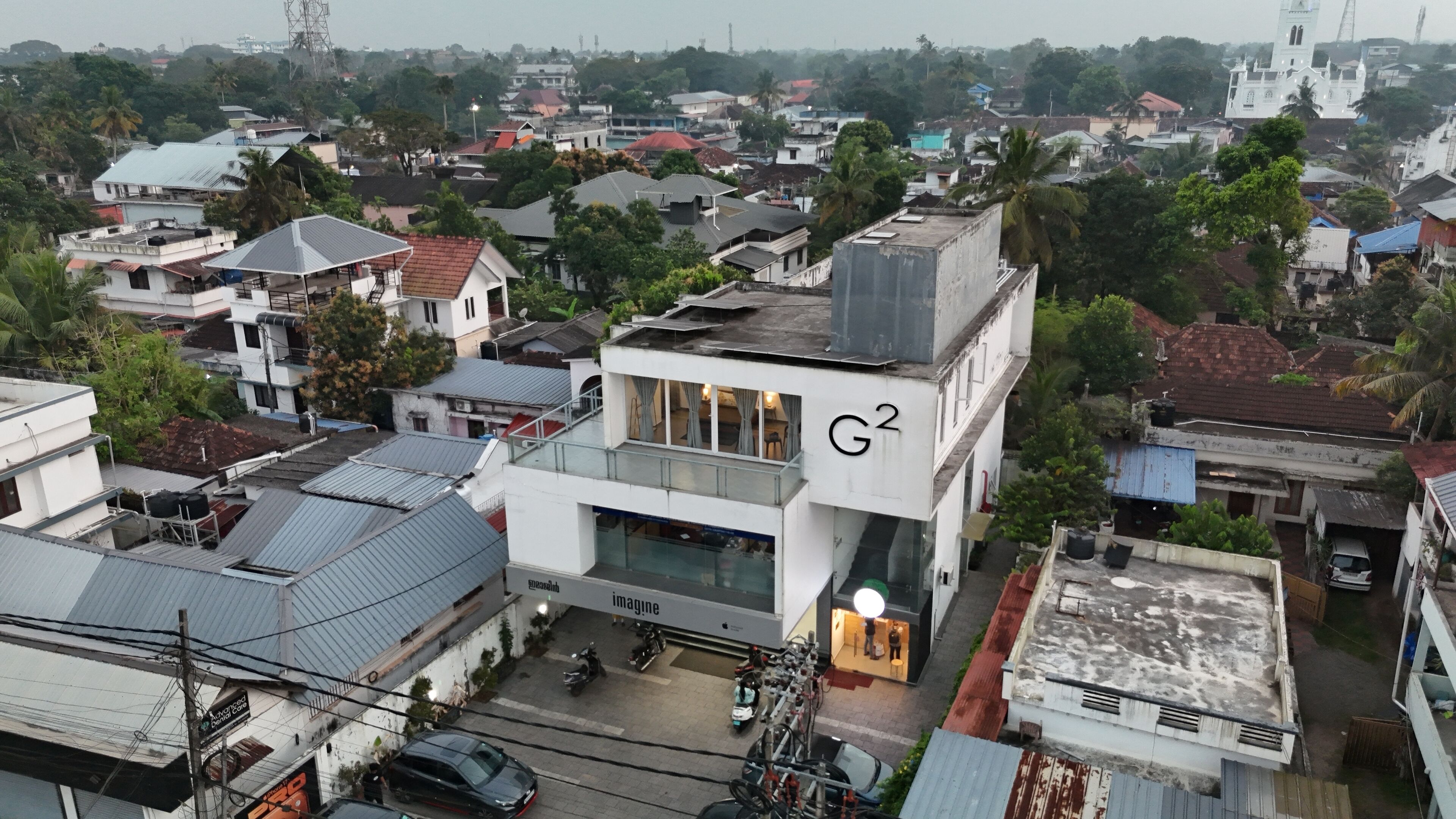 Un immeuble à plusieurs étages, reconnaissable à son grand panneau « G2 », entouré de bâtiments résidentiels et de verdure.