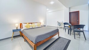 Ein modernes Schlafzimmer mit einem Holzbett, Nachttischen, einem Schreibtisch und zwei Stühlen.